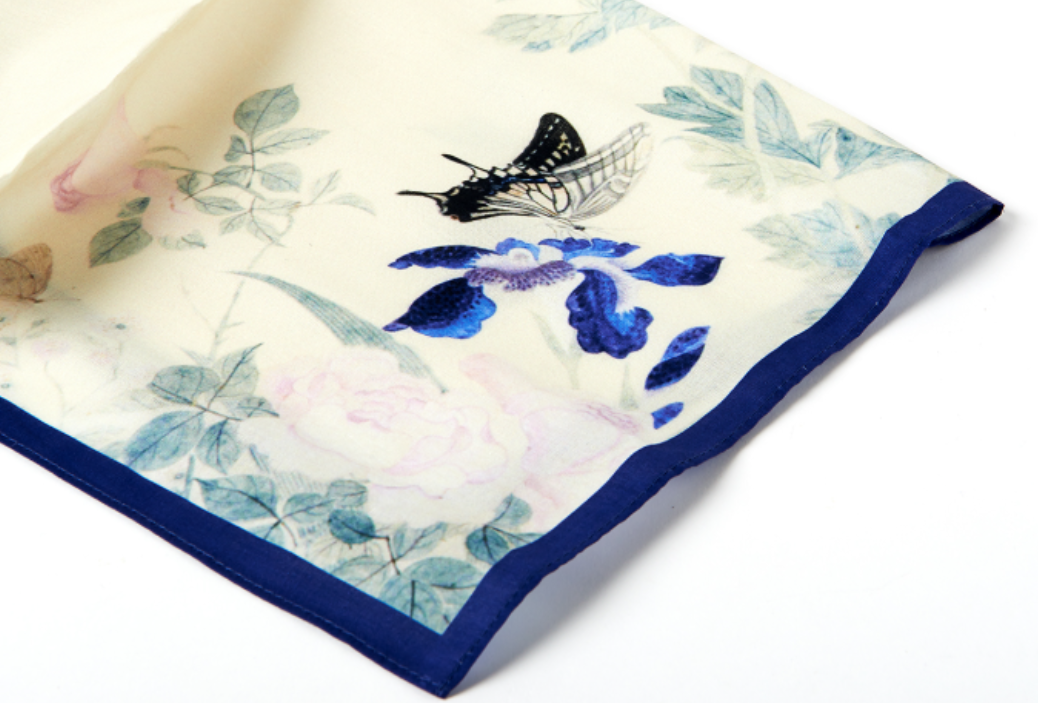 Floral and butterfly patterned fabric square on a white background