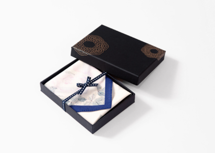 Black box with a white napkin and blue ribbon on a white background